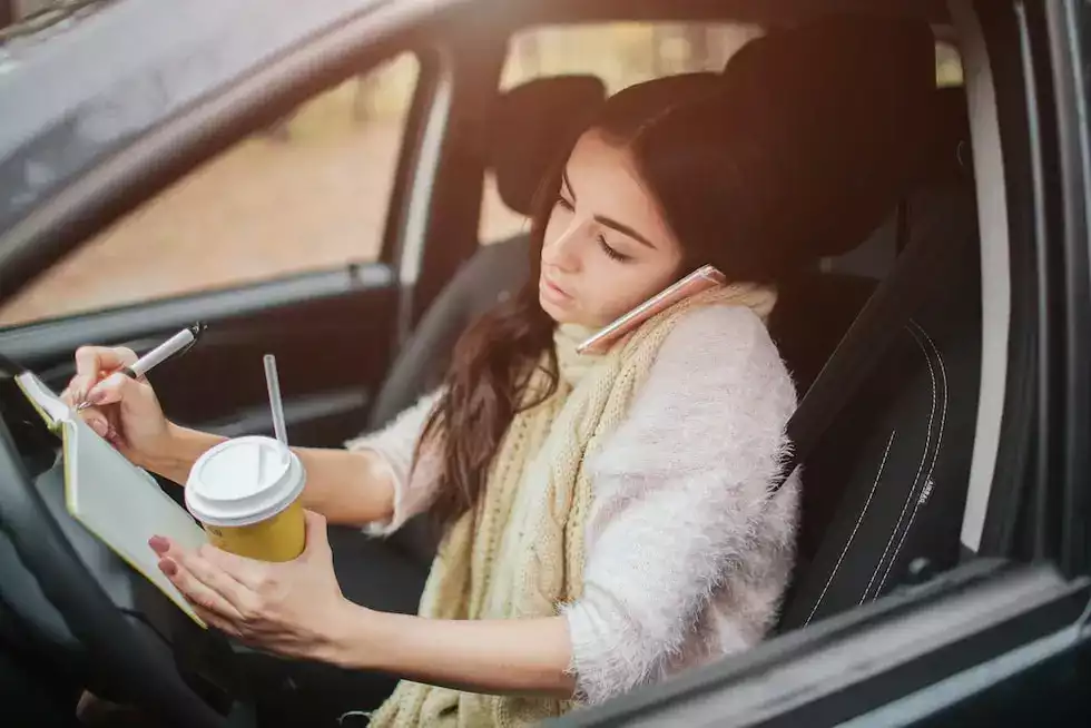 Woman writing notes in car