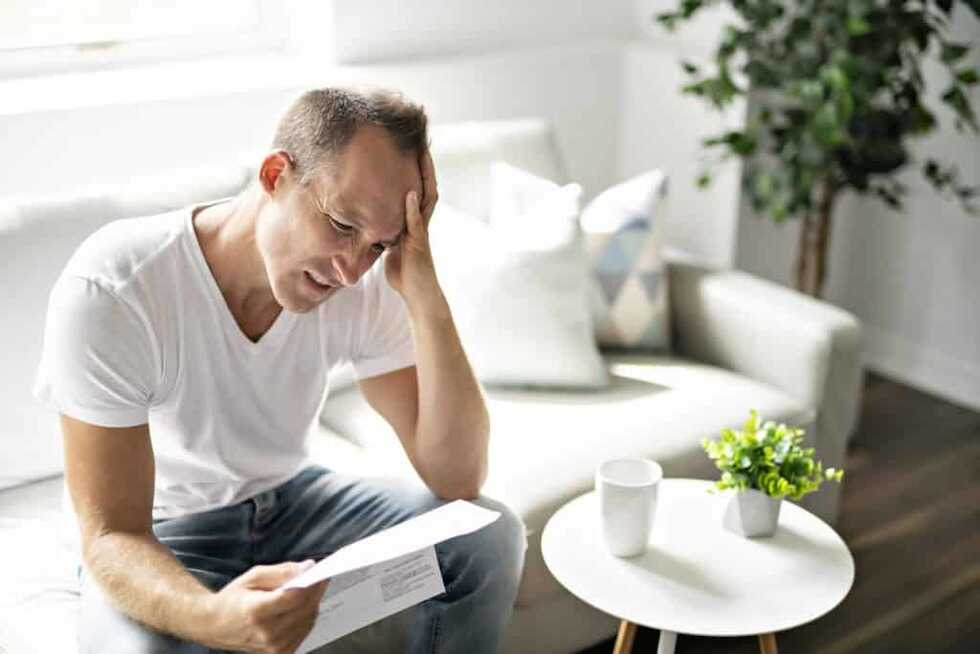 Man has a headache reading his bill